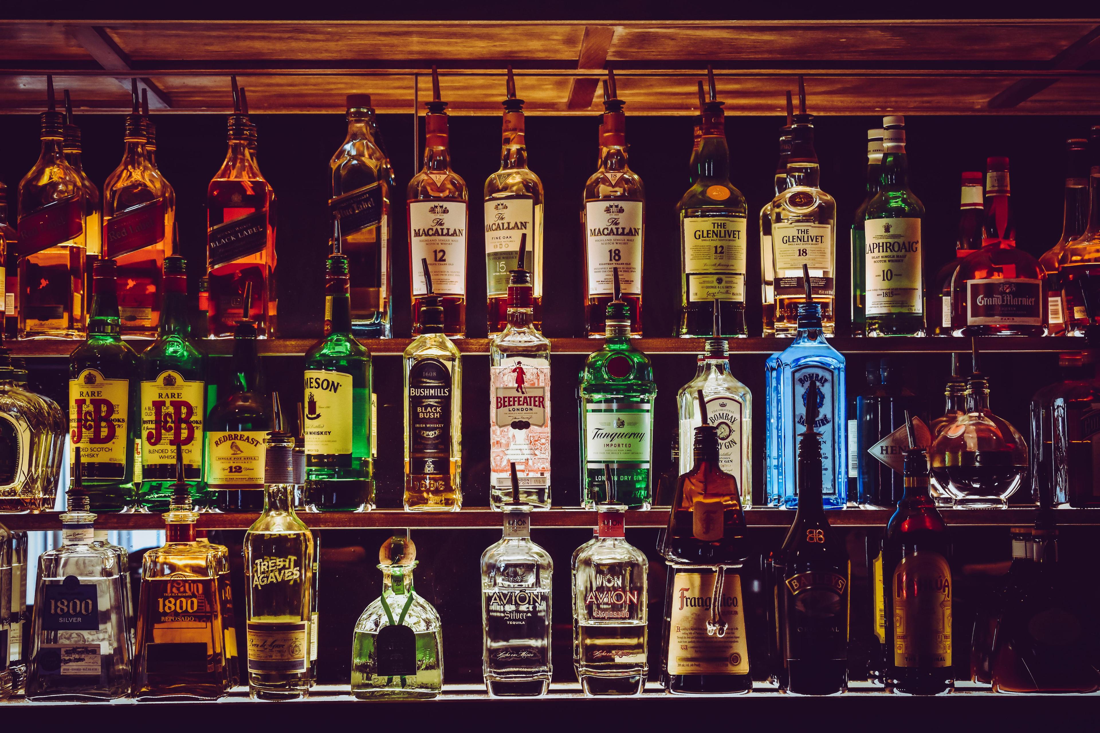 Well-stocked bar shelf with various bottles of alcoholic beverages